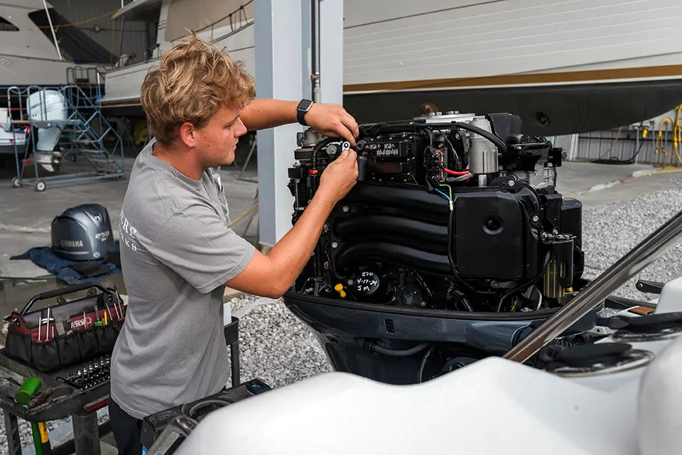 boat owner inspecting a 50hp outboard motor before launching