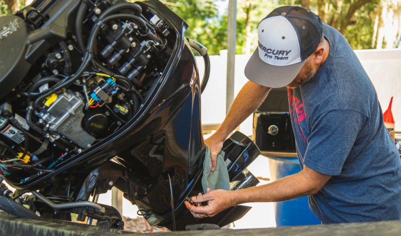marine mechanic performing a compression test on an outboard motor.